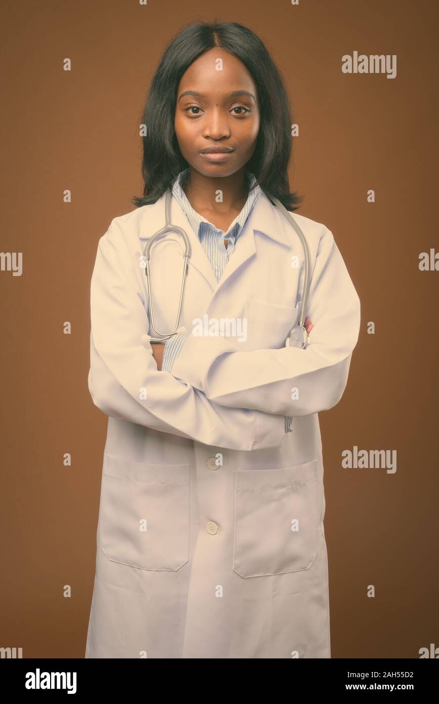 Studio shot of young beautiful African Zulu woman doctor against brown ...