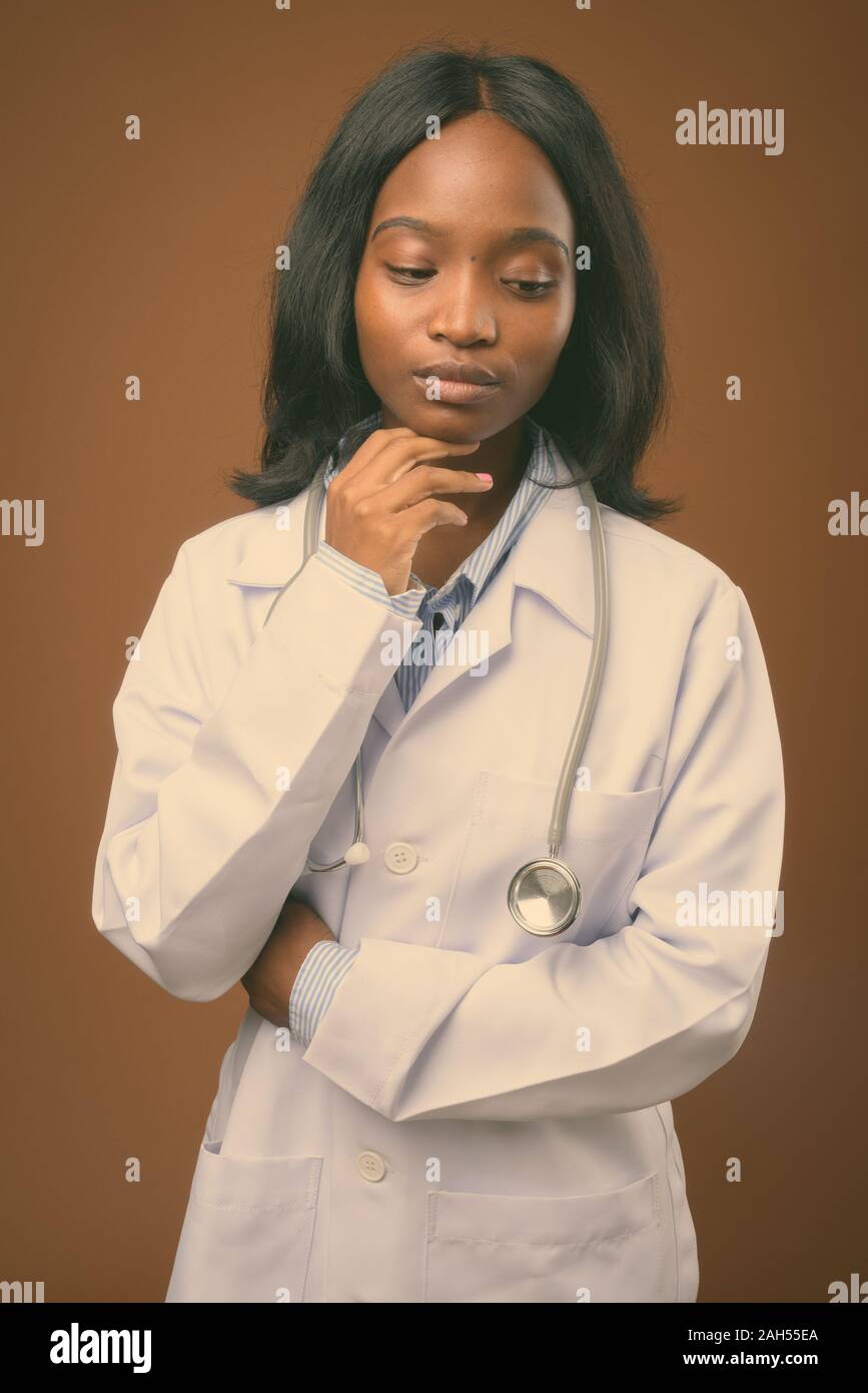 Studio shot of young beautiful African Zulu woman doctor against brown ...