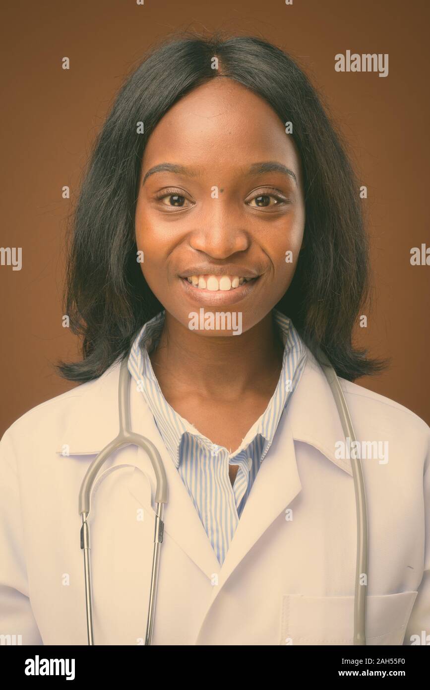 Studio shot of young beautiful African Zulu woman doctor against brown ...