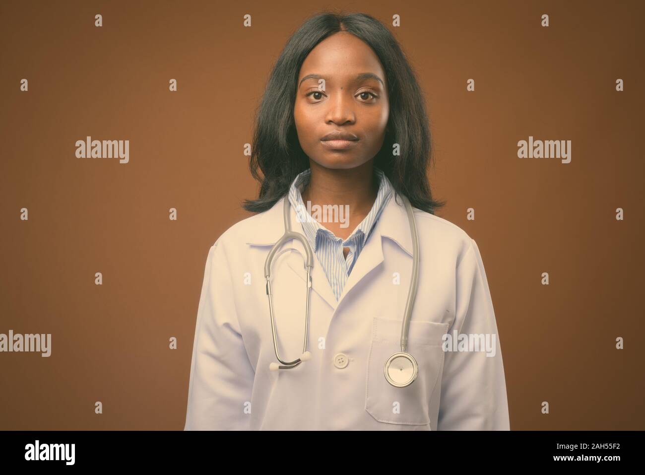 Studio shot of young beautiful African Zulu woman doctor against brown ...