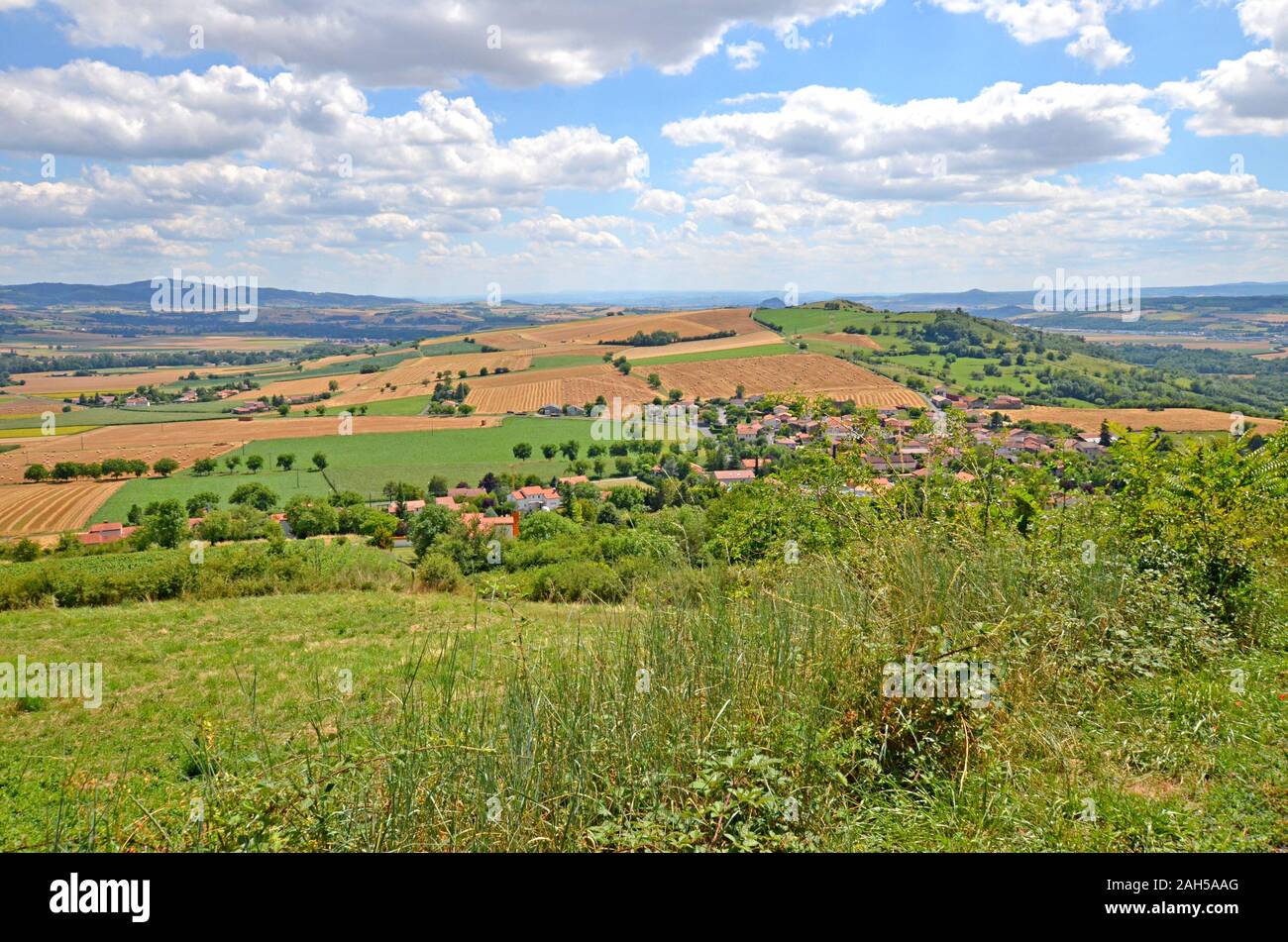 Beautiful rural landscape with blue sky, spectacular clouds and wheat fields in Auvergne region in France Stock Photo