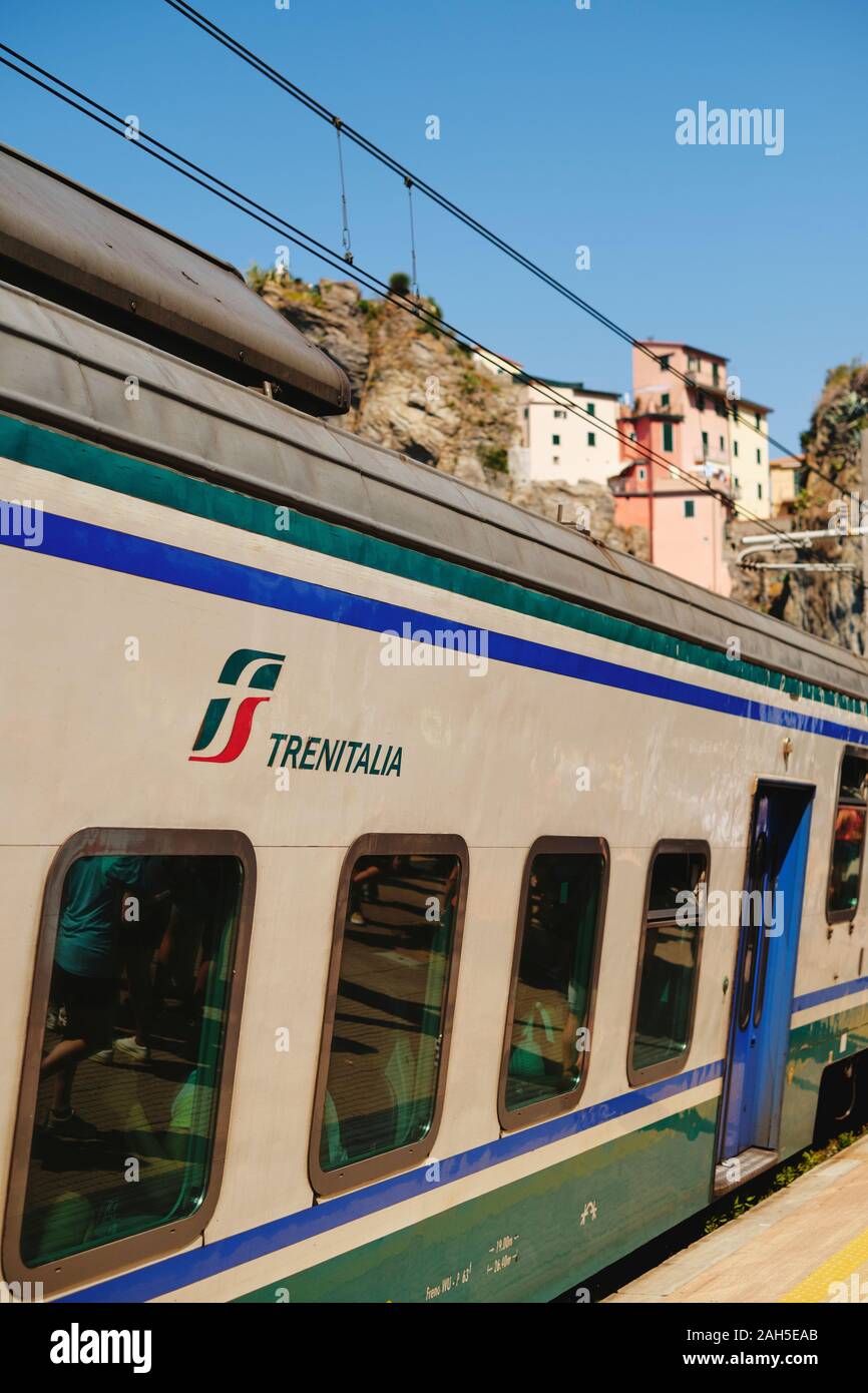 The colourfully painted houses and the TrenItalia train that connects the small fishing villages of the Cinque Terre National Park, Liguria Italy EU Stock Photo