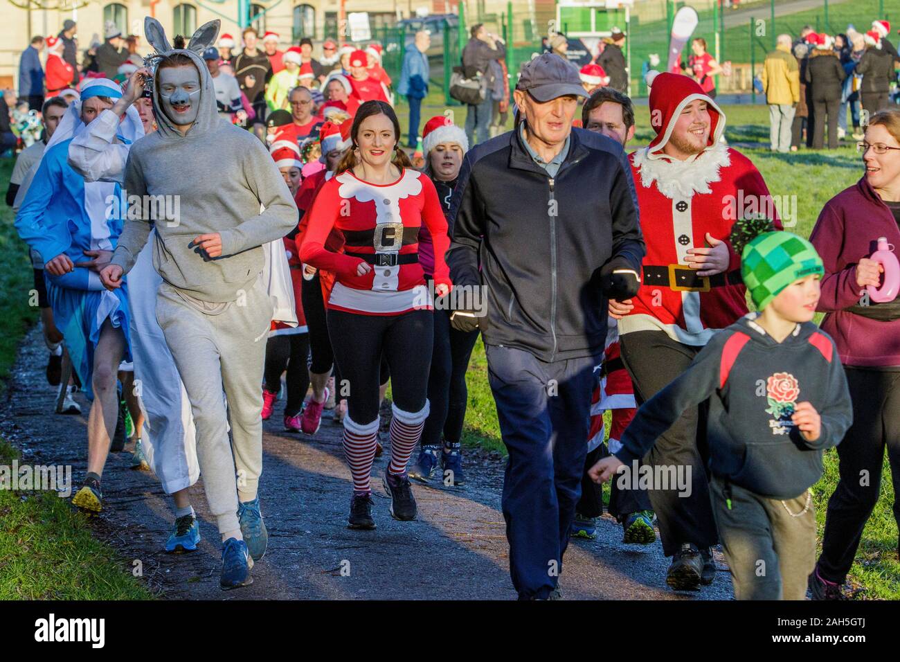 Chippenham, Wiltshire, UK. 25th December, 2019. Runners in fancy dress are pictured as they take part in an early morning Christmas day 5km parkrun in Monkton Park, Chippenham, Wiltshire. 400-500 people participated in the event with many dressing up in fancy dress. Credit: Lynchpics/Alamy Live News Stock Photo
