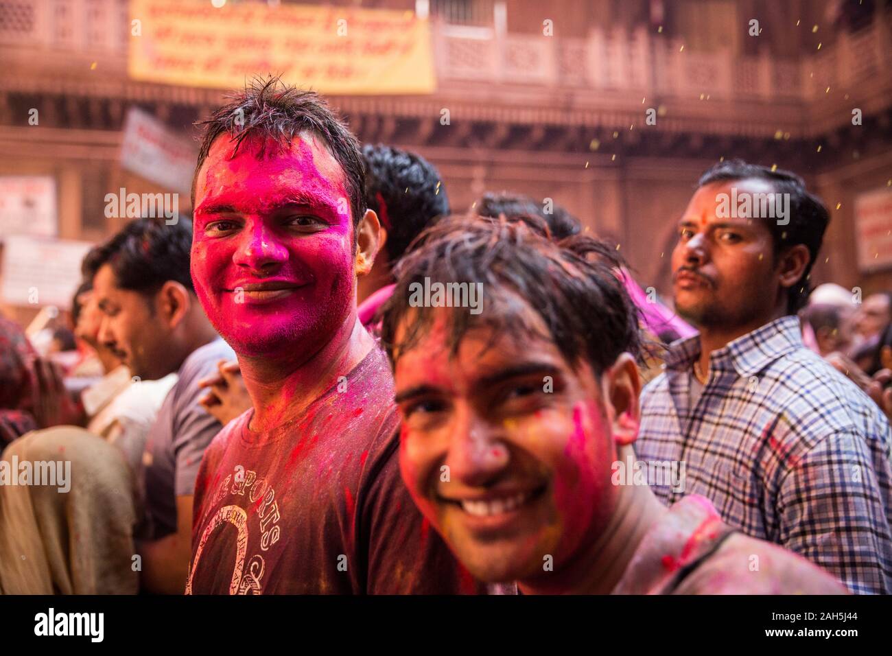 Man covered in pink inside Bankey Bihari temple while attending Holi celebrations. Vrindavan, India Stock Photo