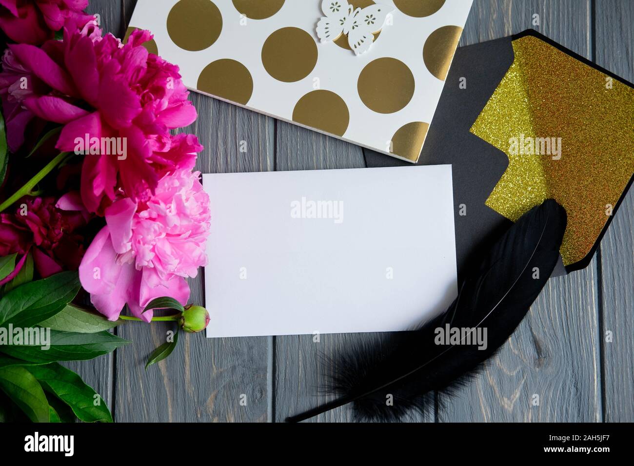 Background with peonies. Pink and burgundy peonies on a wooden background with space for copywriting. Frame for text with flowers. Greeting card with Stock Photo