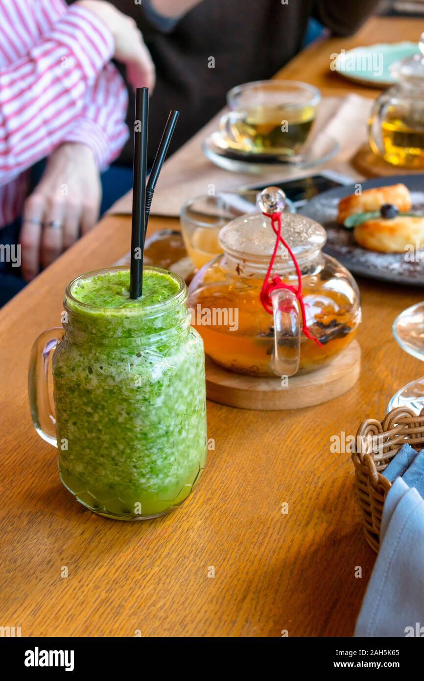 Glass of green smoothies with fresh green tea on a table in a cafe. Stock Photo