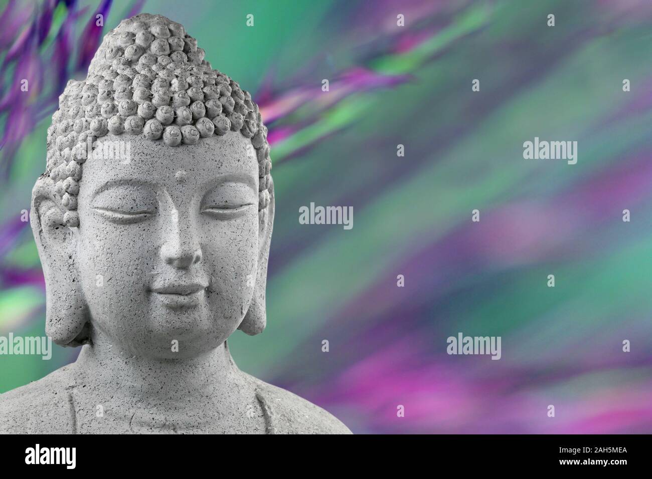 buddha statue head isolated on blurred green and purple background with copy space Stock Photo