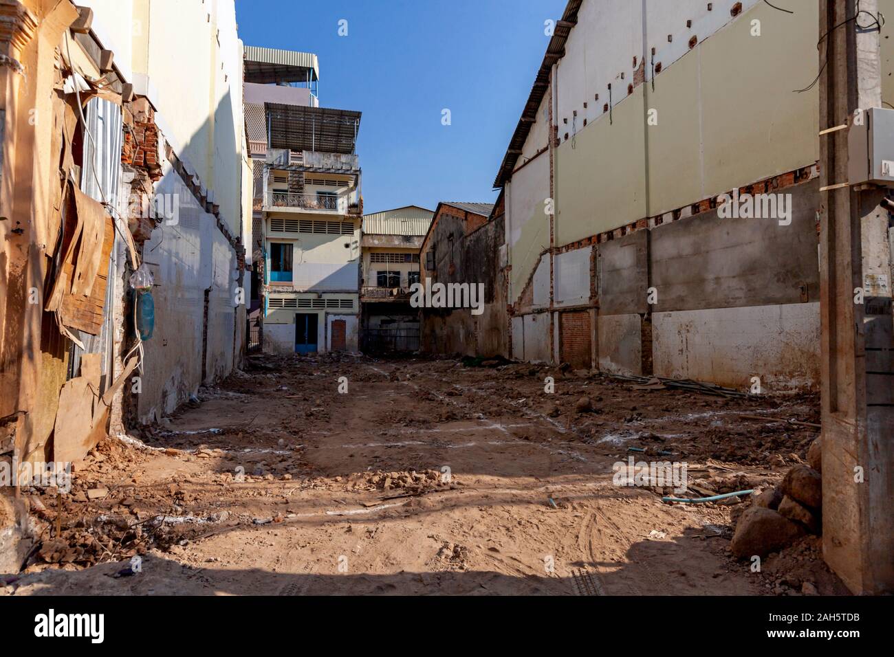 A vacant plot of land awaits the construction of a new shophouse on a city street in Kampong Cham, Cambodia. Stock Photo