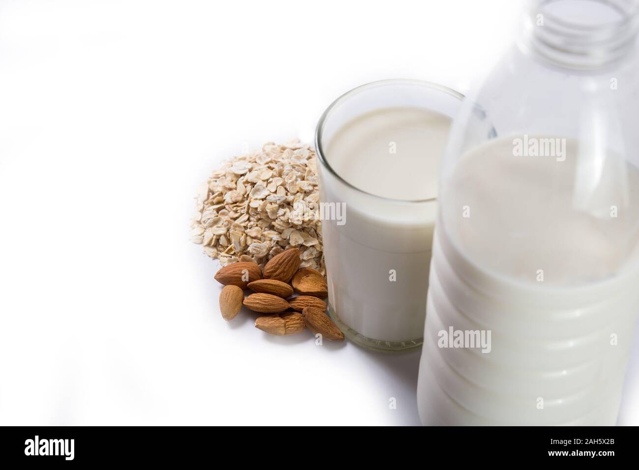 vegan milk made of oat and almong on a botttle andd in a glass, on a white backgorund Stock Photo