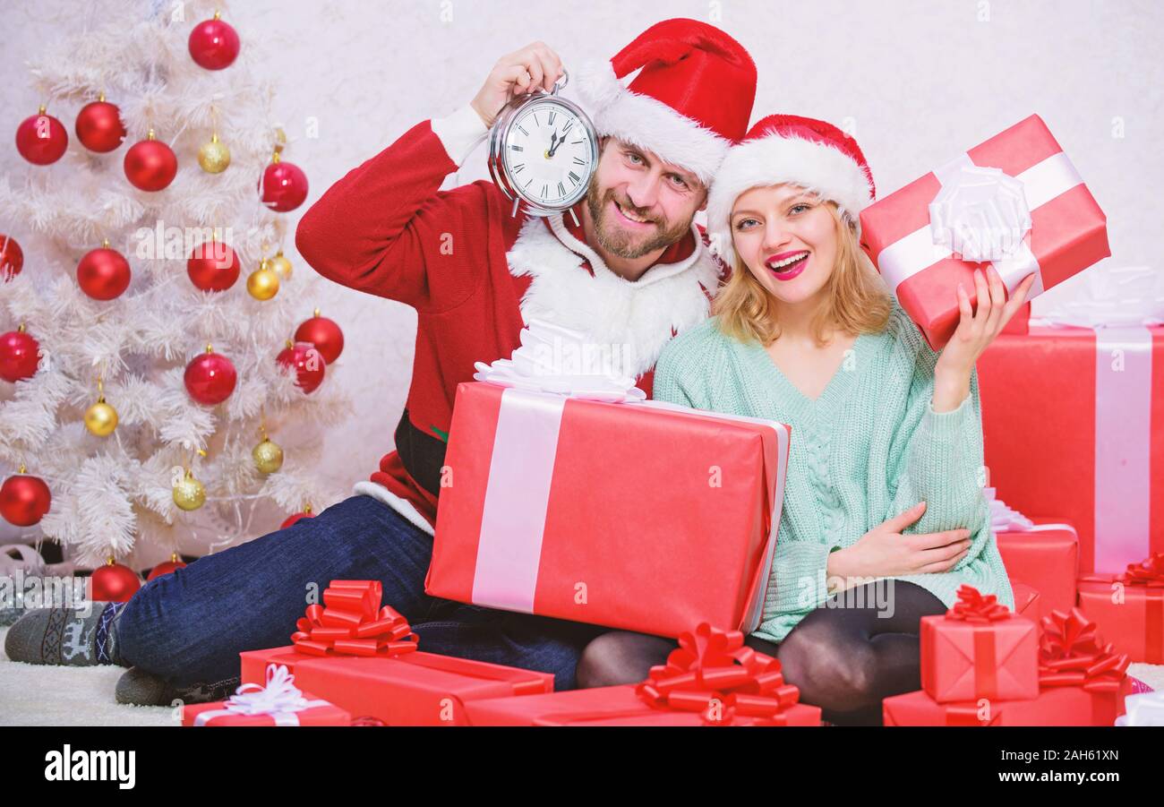 Christmas fun concept. Couple wear hats as santa claus christmas tree background. Couple in love enjoy christmas celebration. It is easy to spread happiness around. Happy family celebrate christmas. Stock Photo