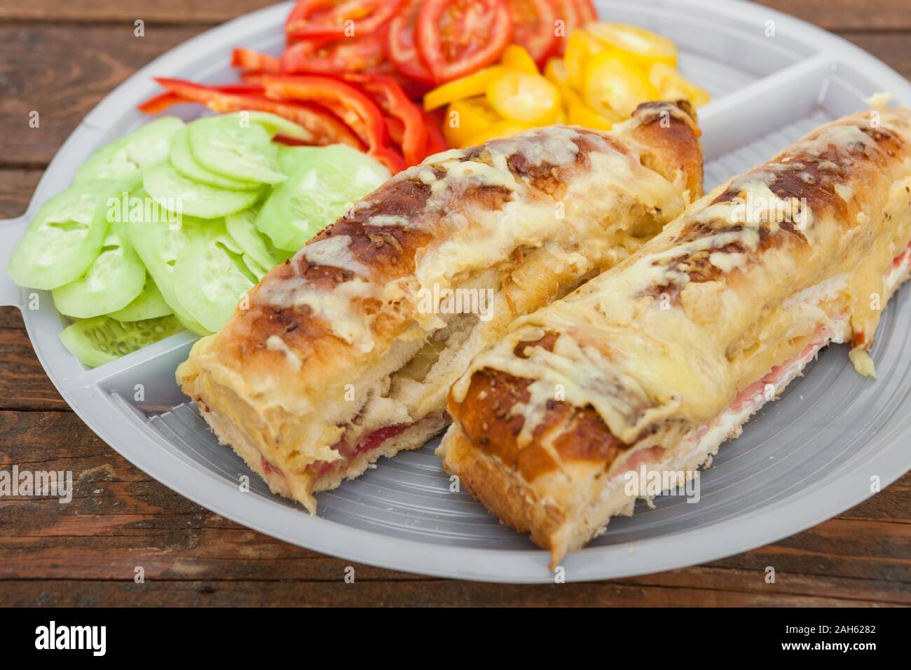Tasty sandwich with ham, melted cheese and vegetables Stock Photo