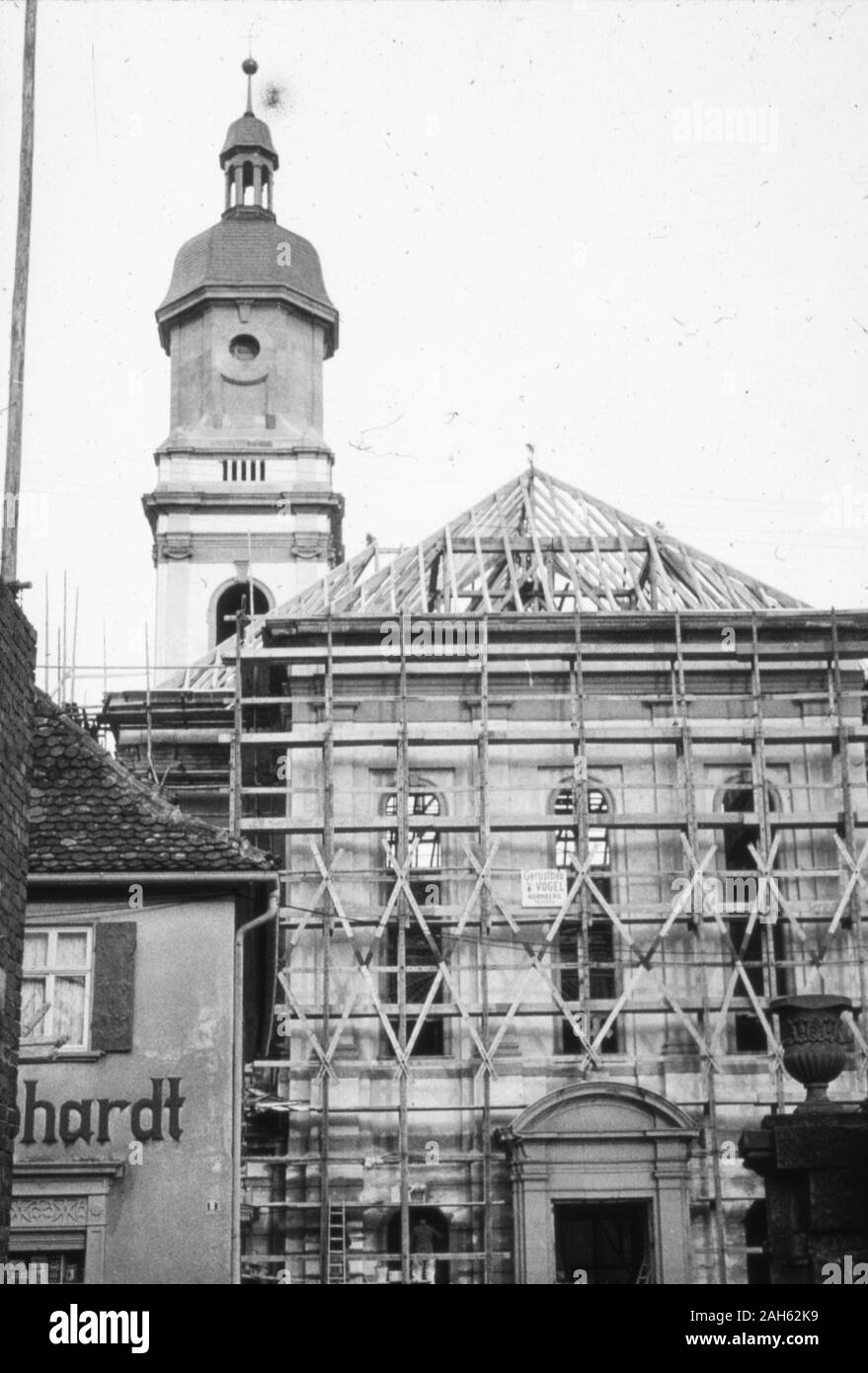Blick vom Anwesen der ehemaligen Schmiede Wolf in der Würzburger Straße in Uffenheim/Mittelfranken auf die wiederaufgebaute Stadtkirche St. Johannis 1953. Die Kirche ist nahezu fertigestellt, es fehlt noch das Dach des Kirchengebäudes und die Turmuhr. Links das Haus der Gemischtwarenhandlung Gebhardt. Stock Photo