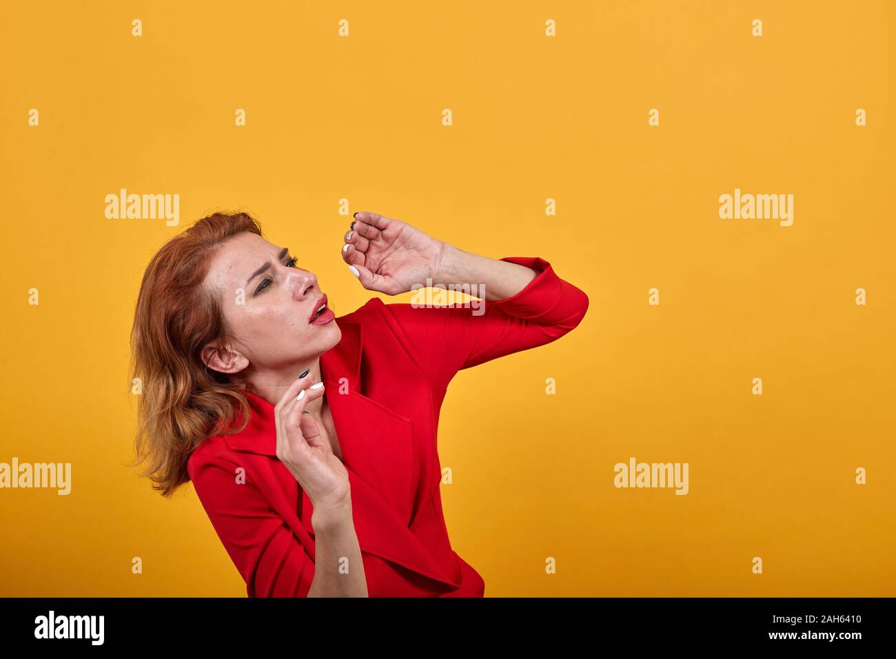 Scared caucasian young lady dodging a punch, cowering Stock Photo