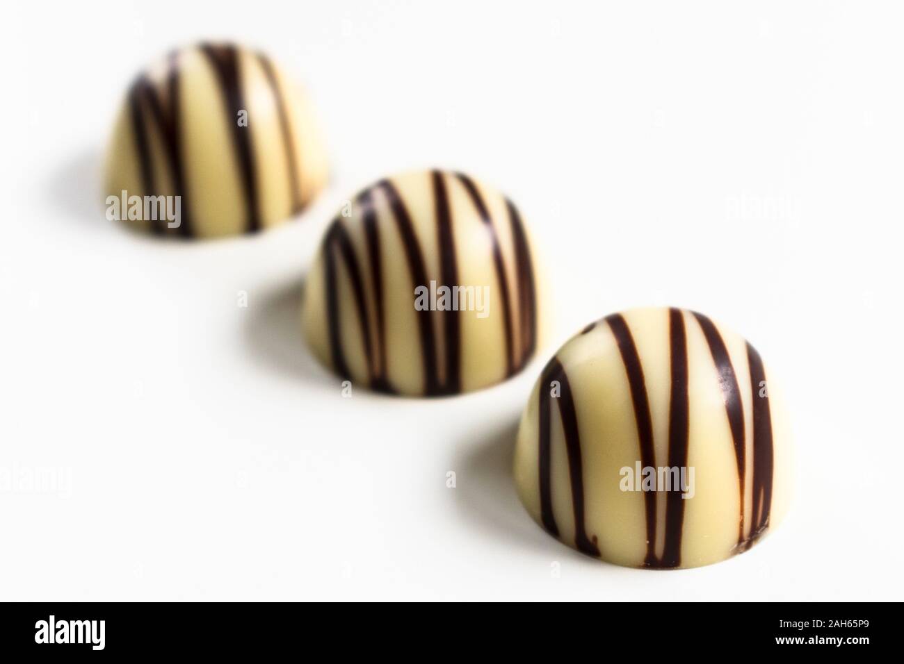 Three white chocolate candies isolated on a white background. Stock Photo