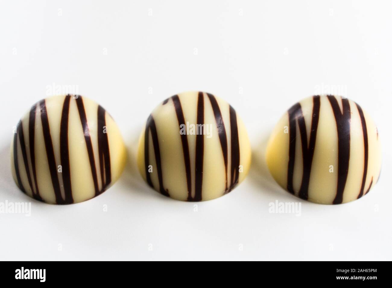 Three white chocolate candies isolated on a white background. Stock Photo