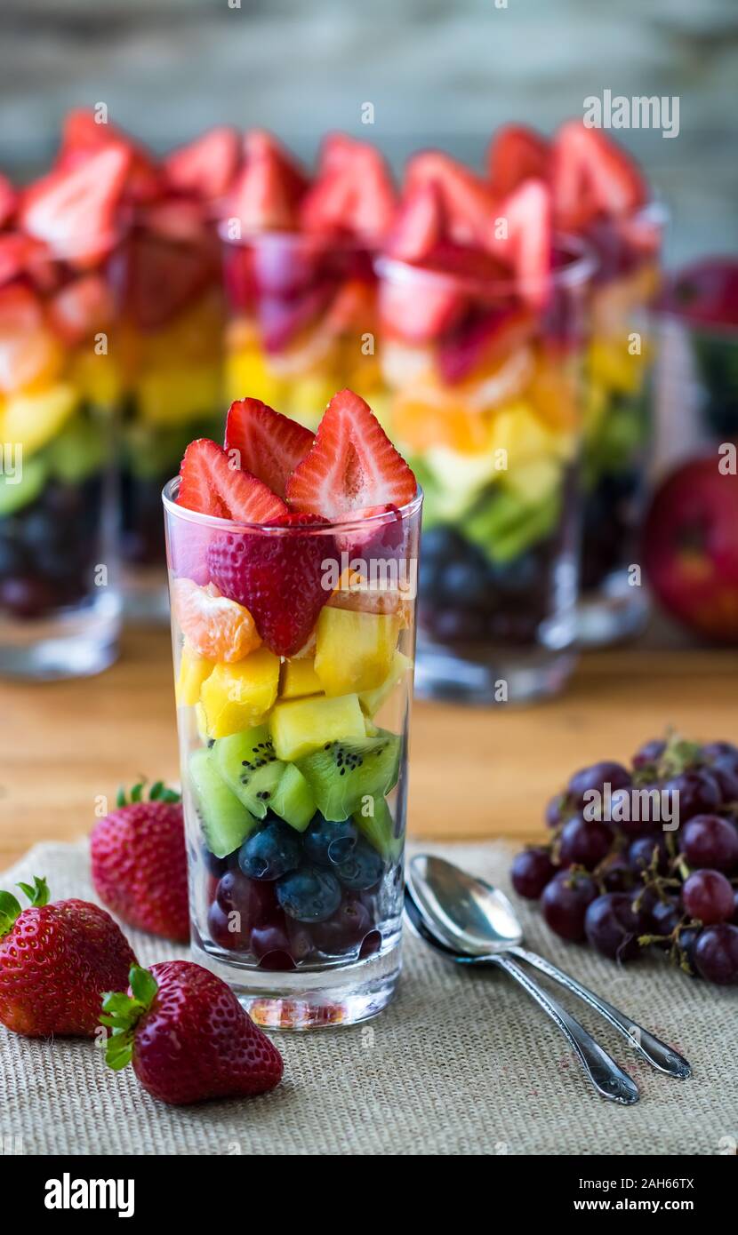 Rainbow fruit salad in tall glasses. Stock Photo