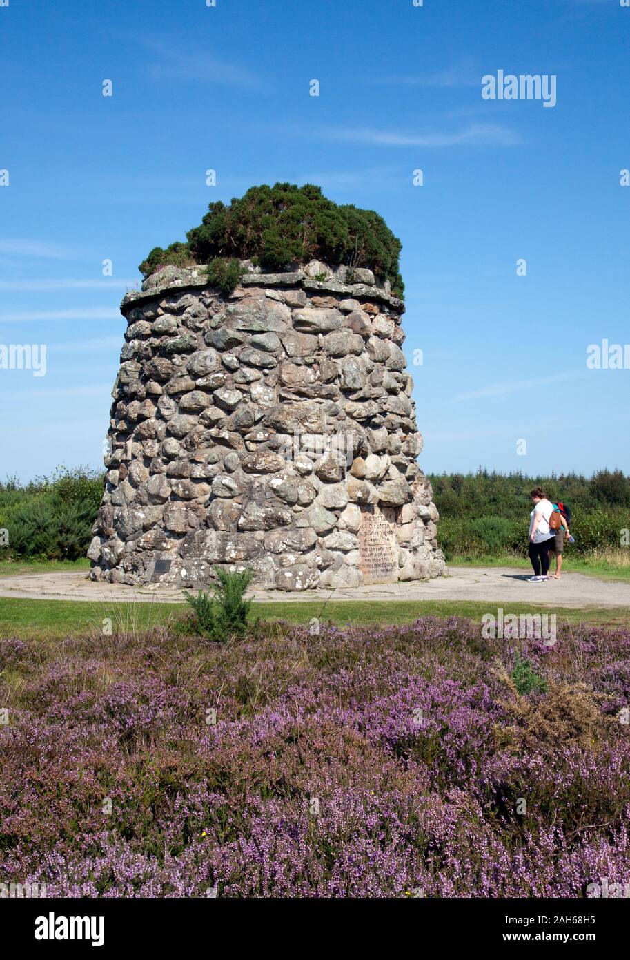 Visitors read the memorial plaque on the monument to the 'Gallant Highlanders' on the site of the  1746 battle of Cullodon Moor, in which British troo Stock Photo