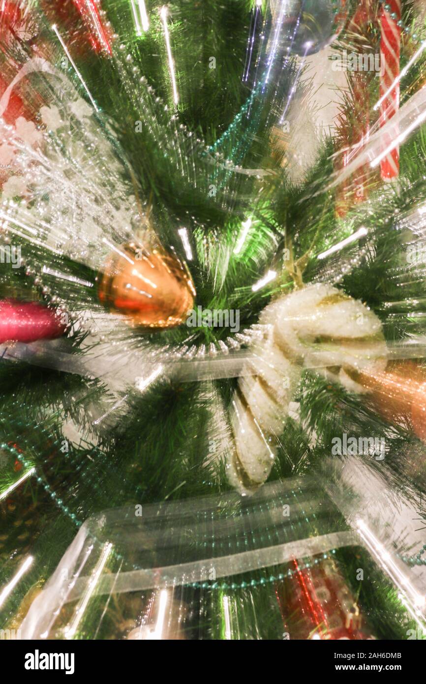 Abstract blurry photo of christmas tree with motion zoom effect, defocused colorful xmas ornaments. Stock Photo