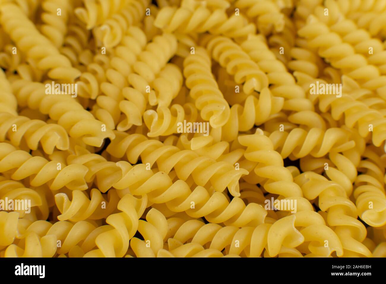 background formed by spiral shaped pasta Stock Photo Alamy