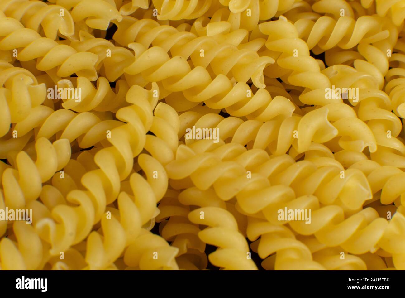 background formed by spiral shaped pasta Stock Photo Alamy