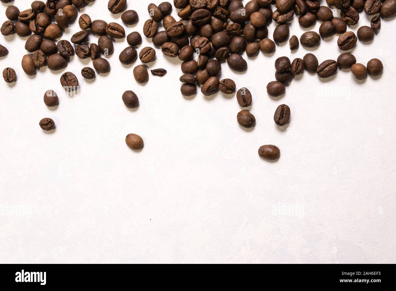 Roasted coffee beans in bulk on a light blue background. dark cofee ...