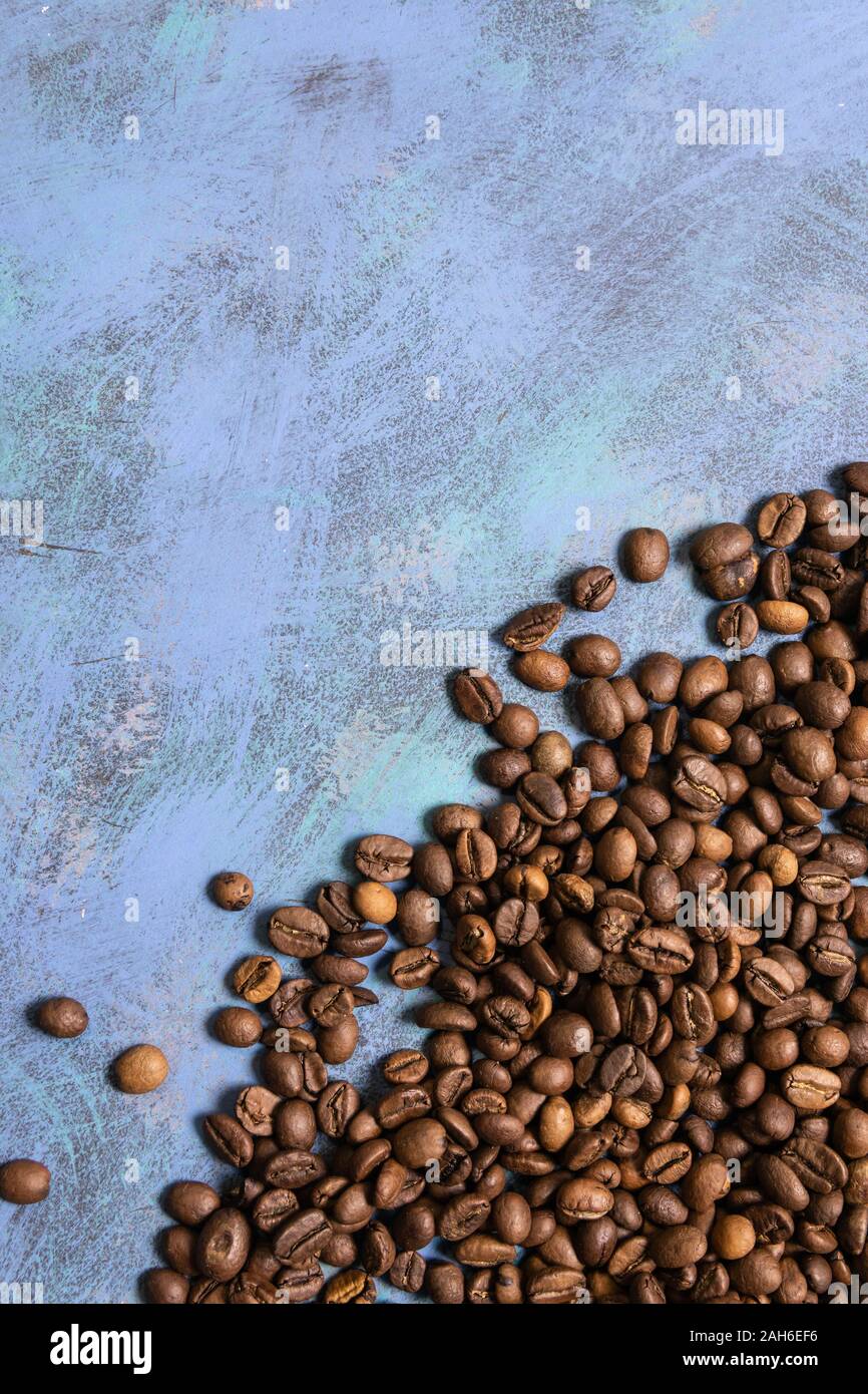 Roasted coffee beans in bulk on a blue background. dark cofee roasted ...