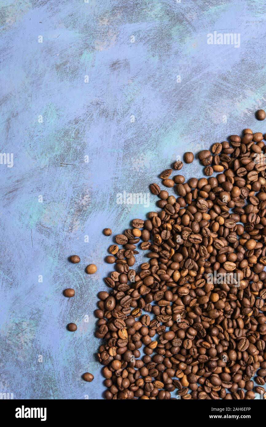 Roasted coffee beans in bulk on a blue background. dark cofee roasted ...
