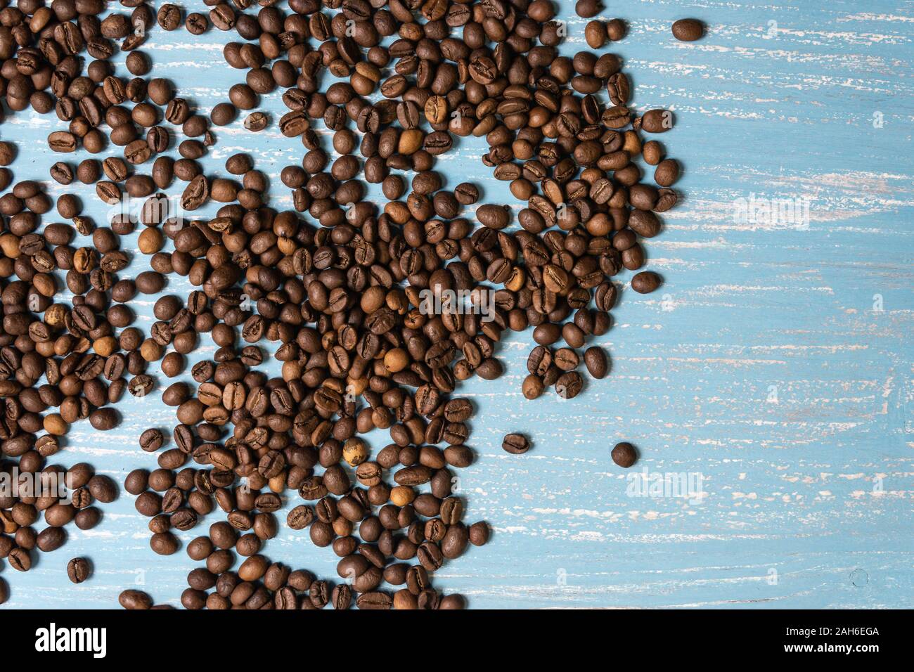 Roasted coffee beans in bulk on a blue wooden background. dark cofee ...
