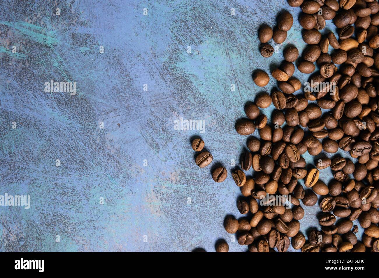 Roasted coffee beans in bulk on a blue background. dark cofee roasted ...