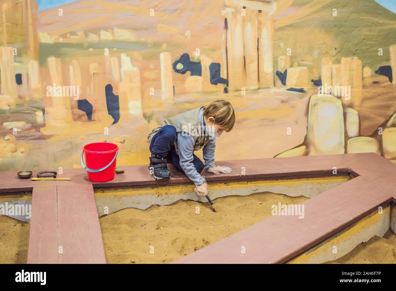 A boy plays a paleontologist, looking for ancient finds in the ground Stock Photo