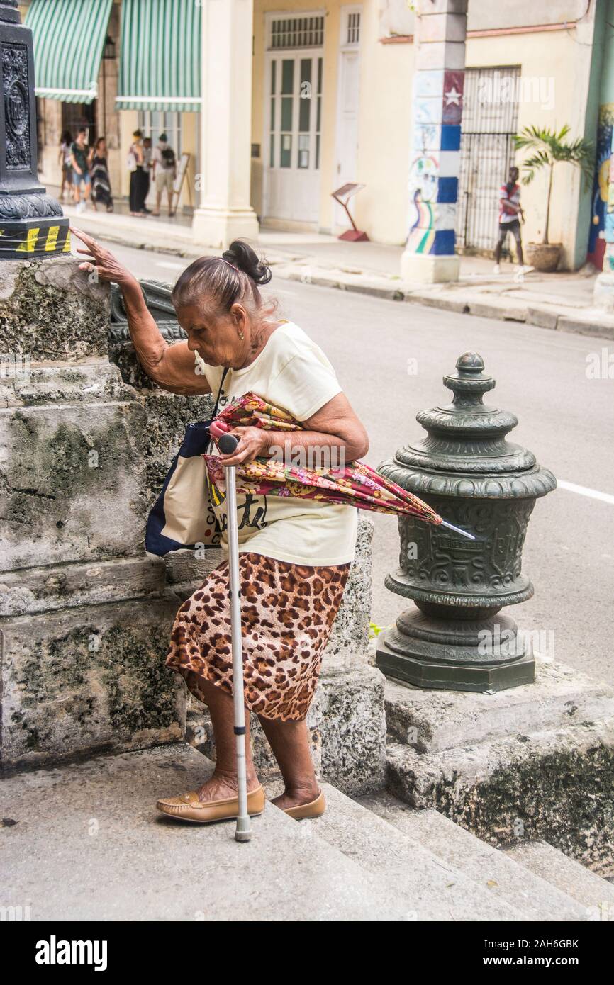People of Havana Series - A senior, retired, Cuban woman, walking up some stairs with her cain. Stock Photo