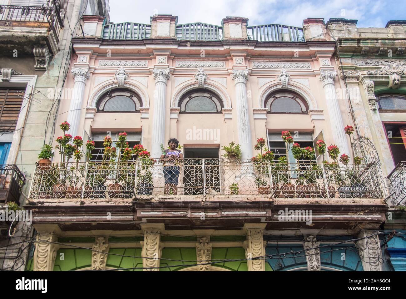 People of Havana Series - A woman standing on the balcony of her apartment, proudly showing off her plants. Stock Photo