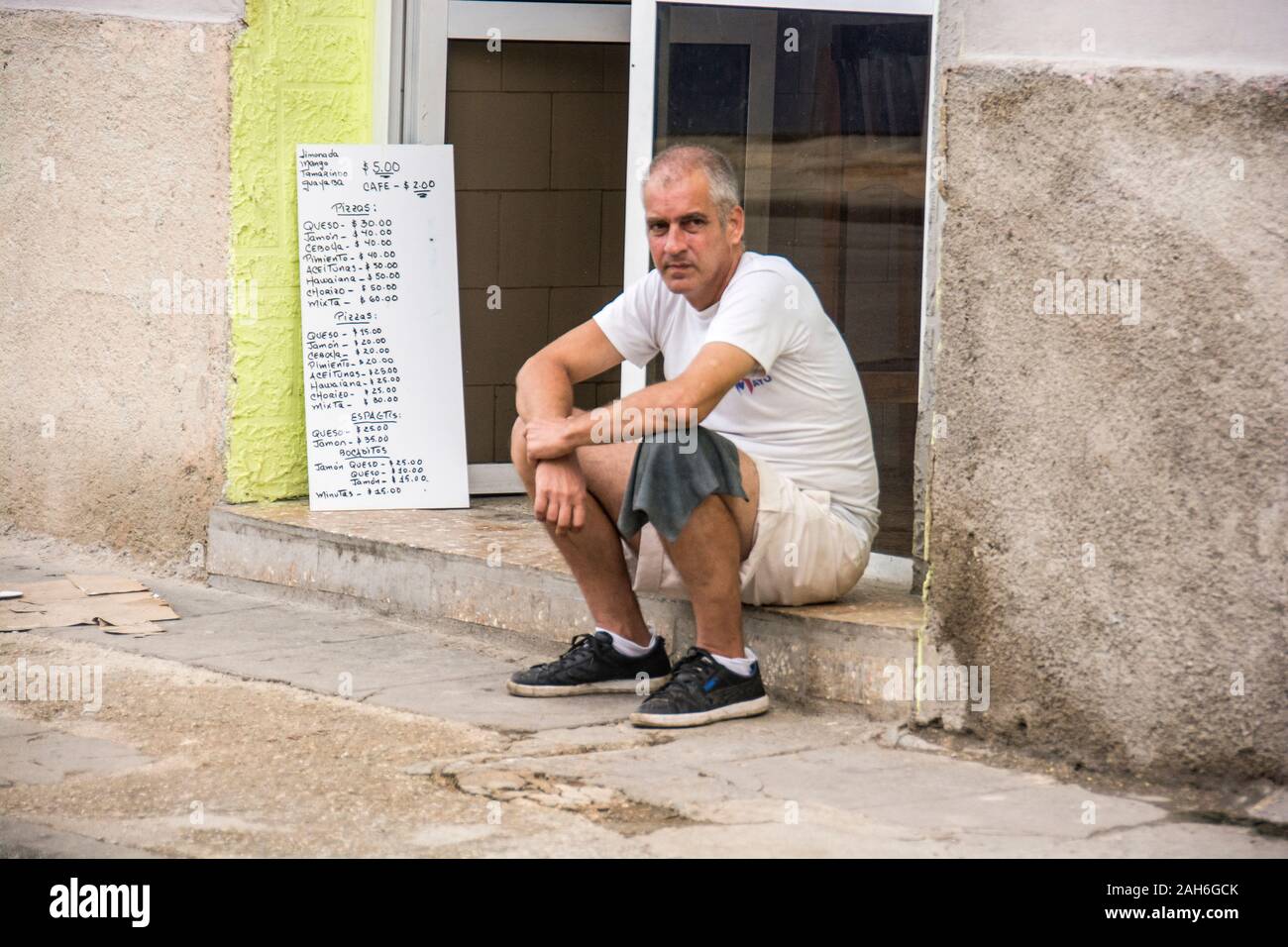 People of Havana Series - A man sitting in front of a restaurant waiting for customers. Stock Photo