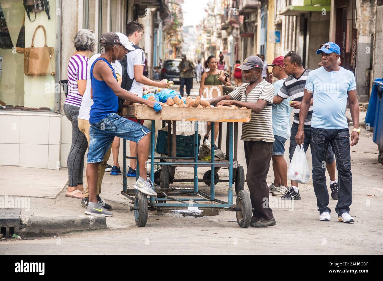 People of Havana Series - A mixed group of Cubans gather around a fruit and vegetable vender to buy food. Stock Photo