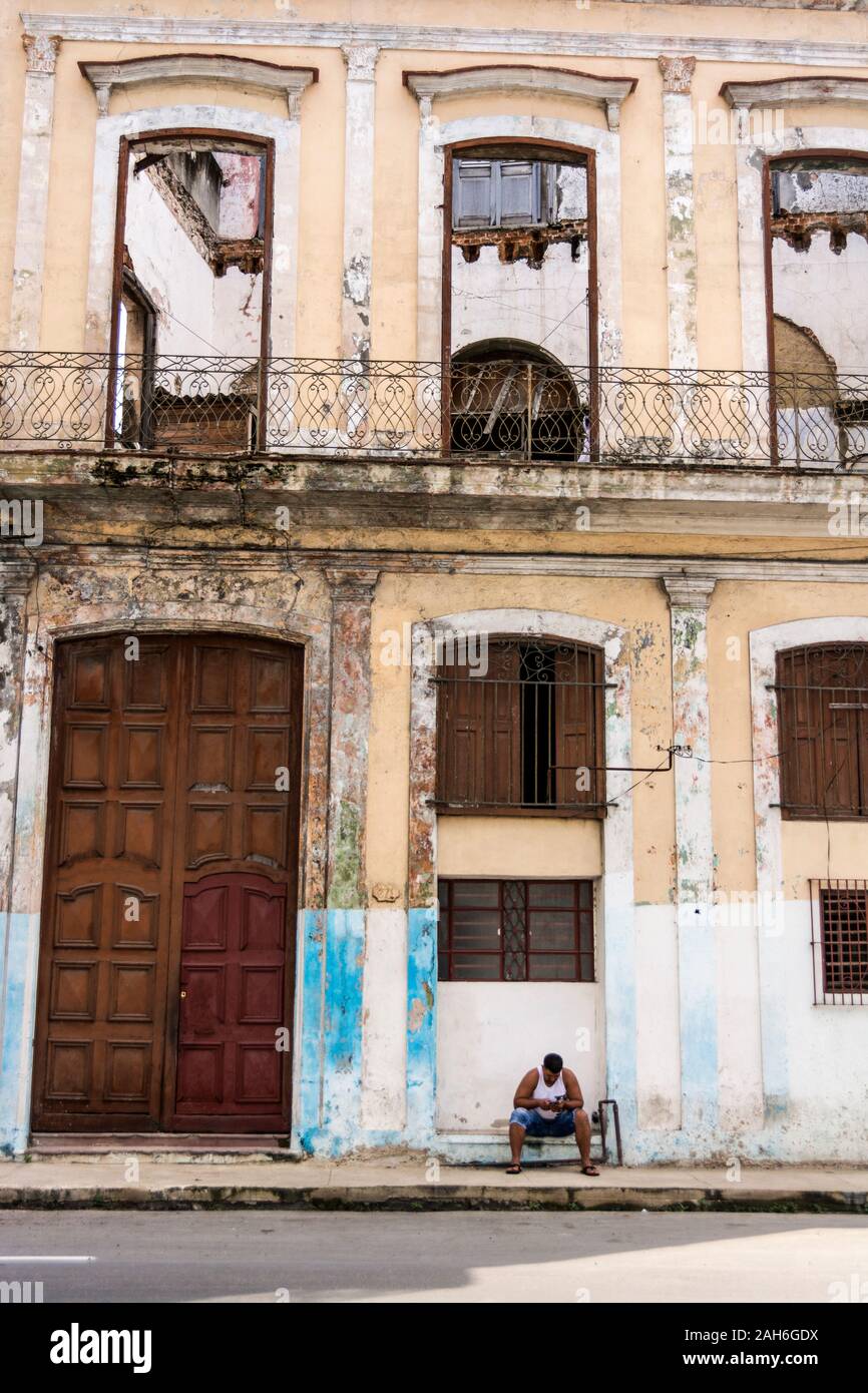 People of Havana Series - A lone man sitting on the floor in front of a building in Havana, Cuba. Stock Photo