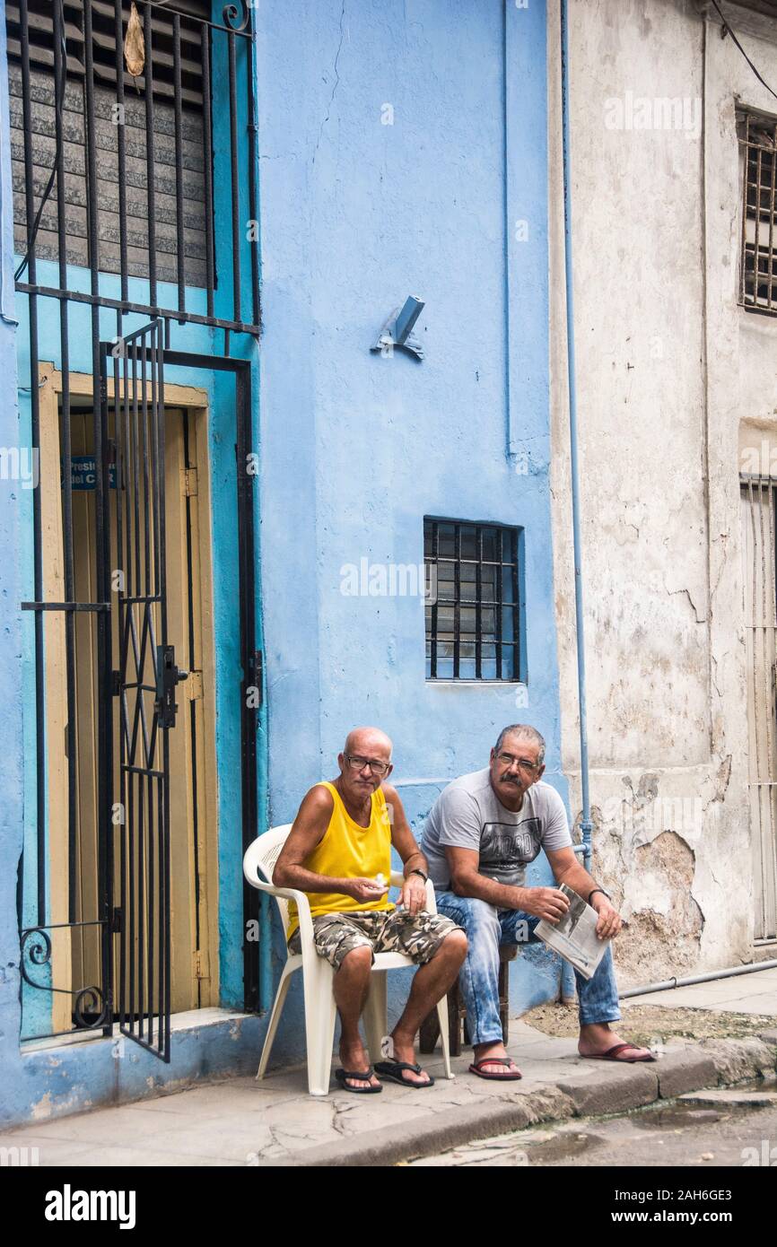 People of Havana Series - Two, older, Cuban men sitting down in front of their homes and chatting. Stock Photo