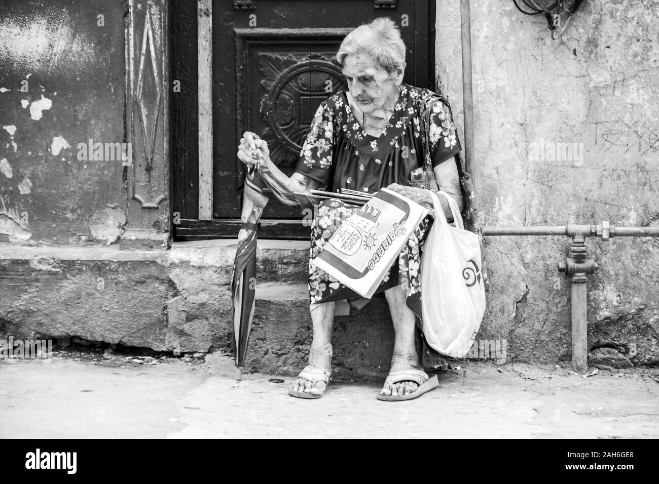 People of Havana Series - An older lady, senior, sitting on the front steps of her apartment. Stock Photo