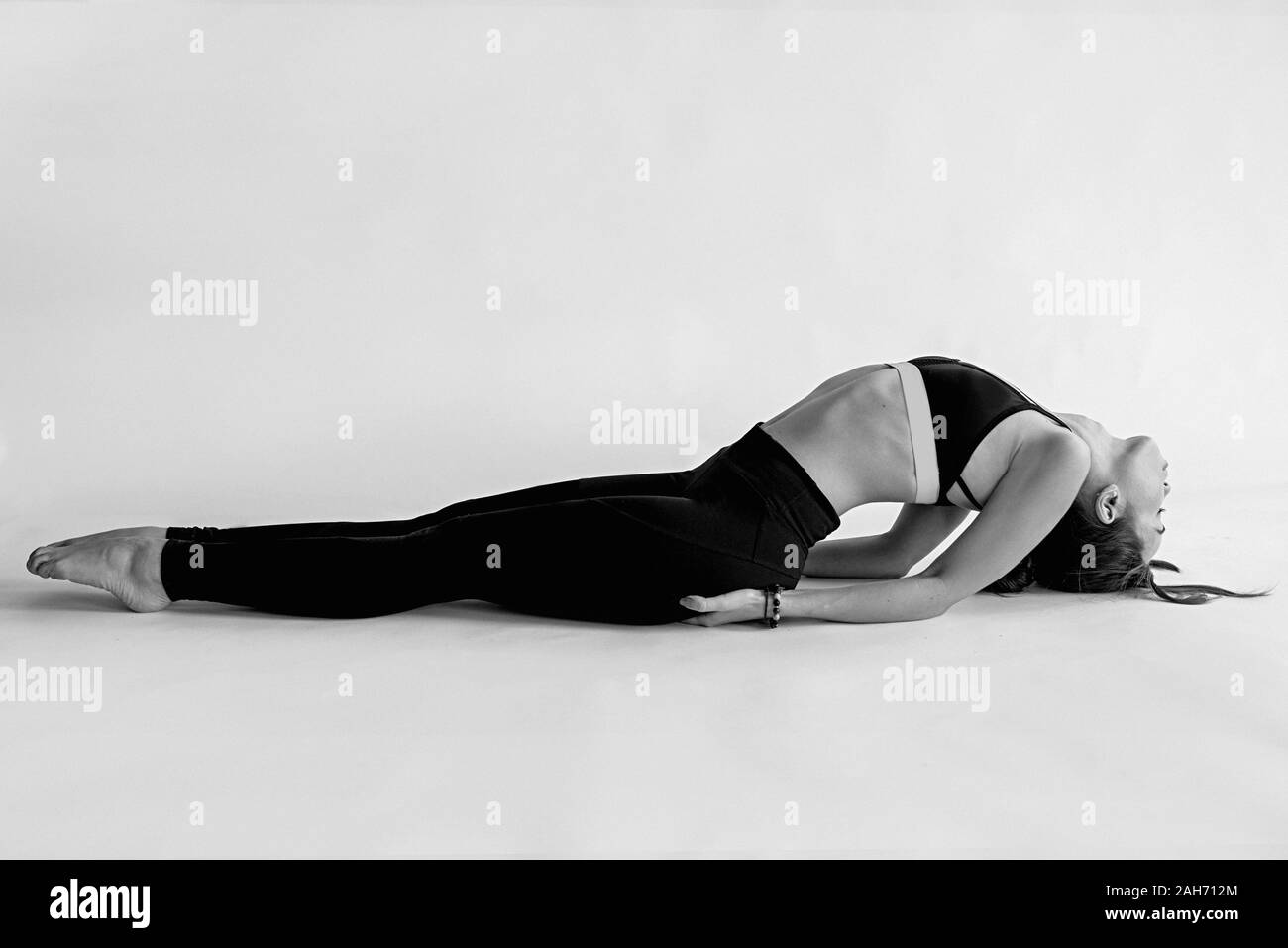 monochrome portrait of caucasian brunette beautiful cheerful woman doing yoga asanas. Healthy lifestyle and sport concept Stock Photo