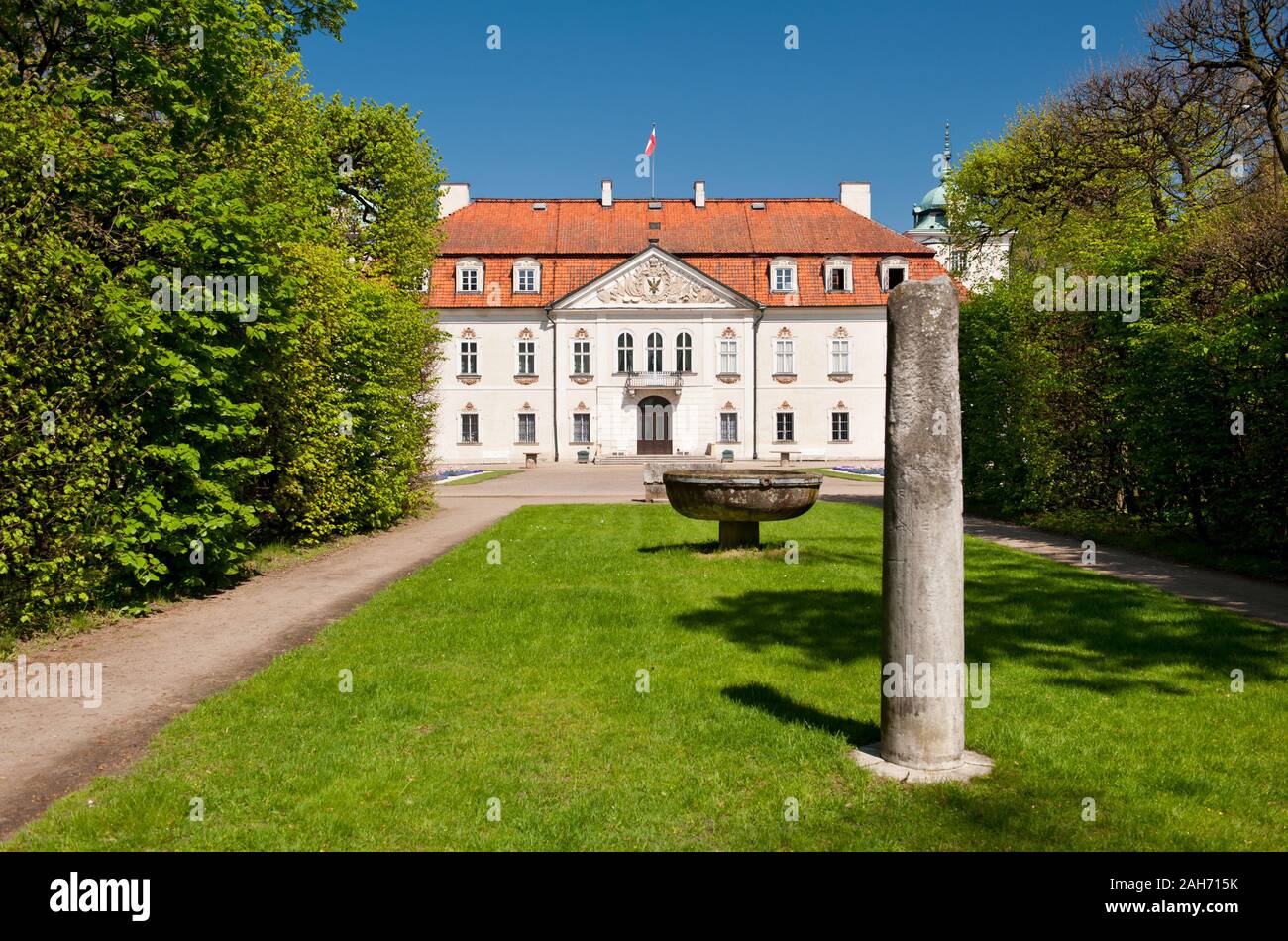 Column in the baroque garden in Nieborów in Poland, Europe, Radziwiłł's Palace across the wide alley view with monuments in ornamental garden. Stock Photo