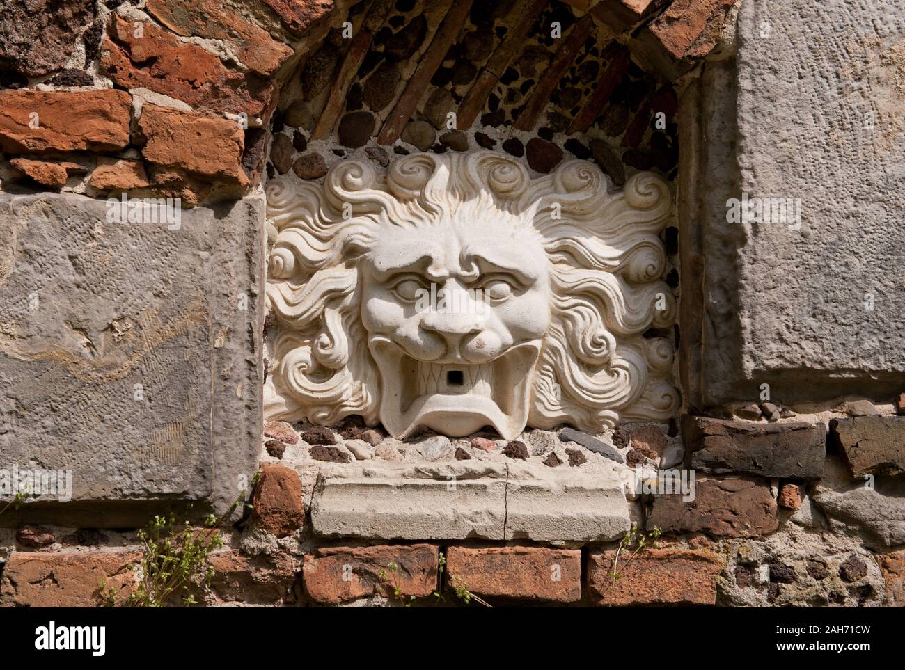 Lion head mascaron sculpture on the Przybytek Arcykapłana exterior wall, the High Priest Sanctuary building in the Romantic Park in Arkadia, Poland. Stock Photo