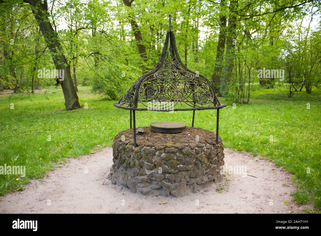 Wrought iron well next to Margraves House building in the Romantic Park in Arkadia, Poland, Europe, visiting tourist travel destinations, sightseeing Stock Photo