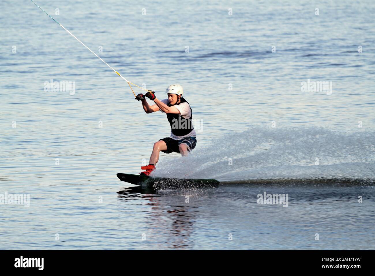 Hämeenlinna Finland 05/31/2016 A young wet man wake boarding on a lake in summertime Stock Photo