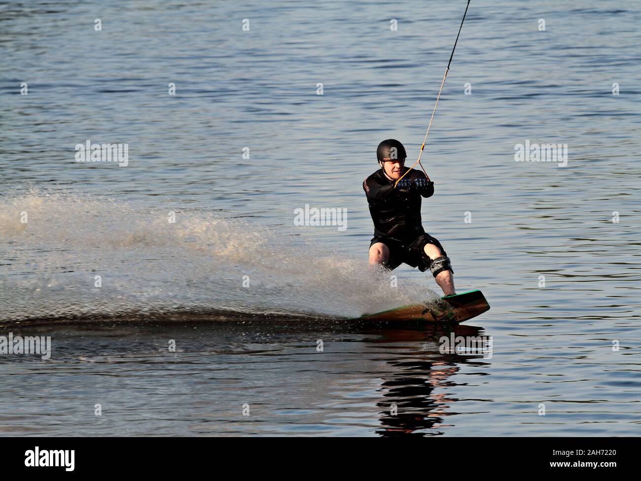 Hämeenlinna Finland 05/31/2016 A young wet man wake boarding on a lake in summertime Stock Photo