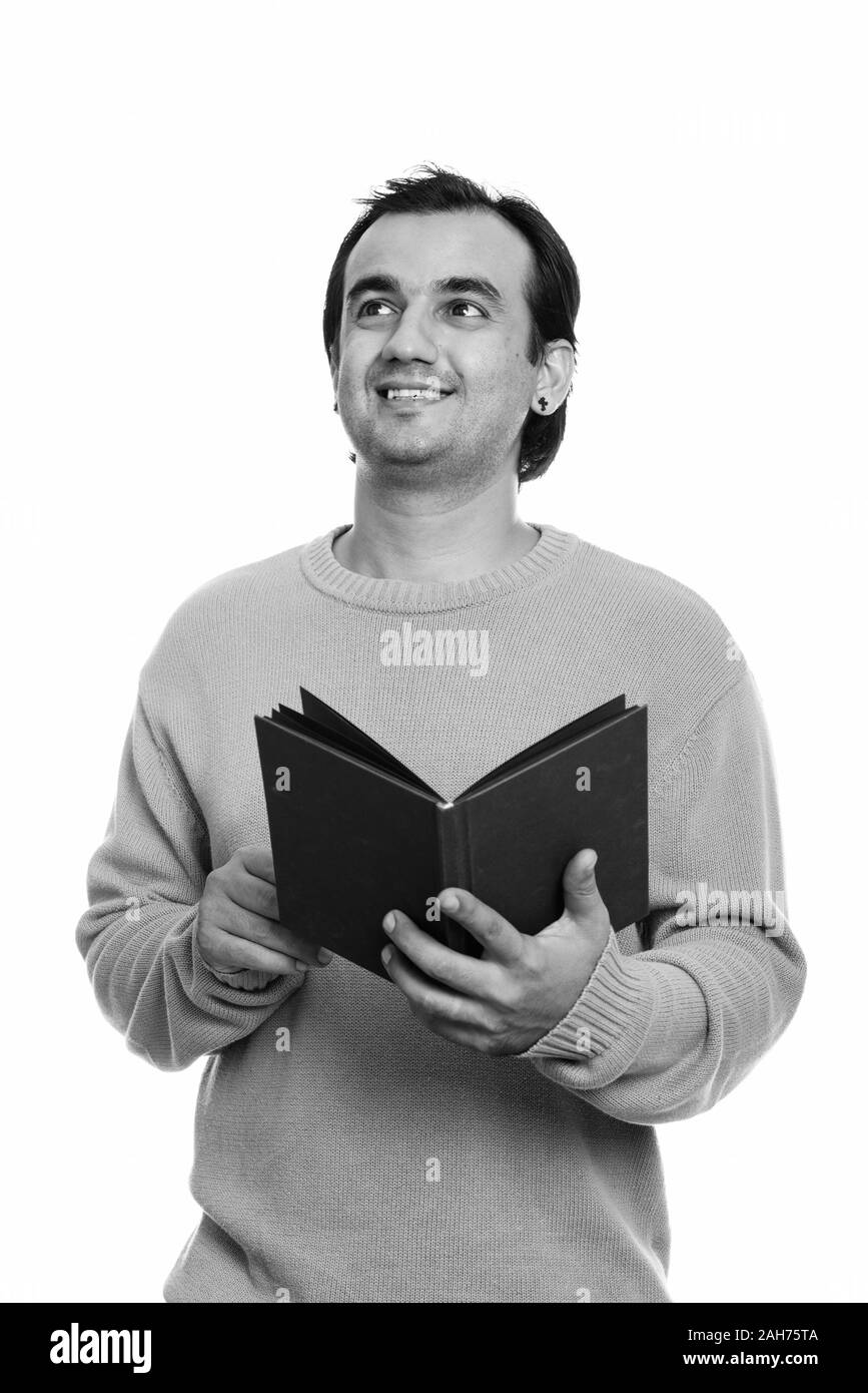Studio shot of happy Persian man smiling while holding book and ...