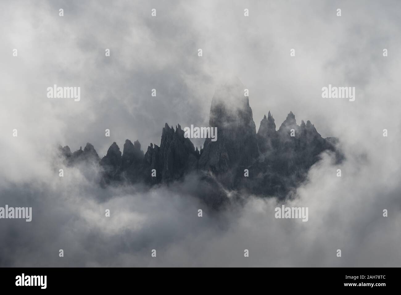 Close up of dark alpine peaks framed by stormy clouds Stock Photo
