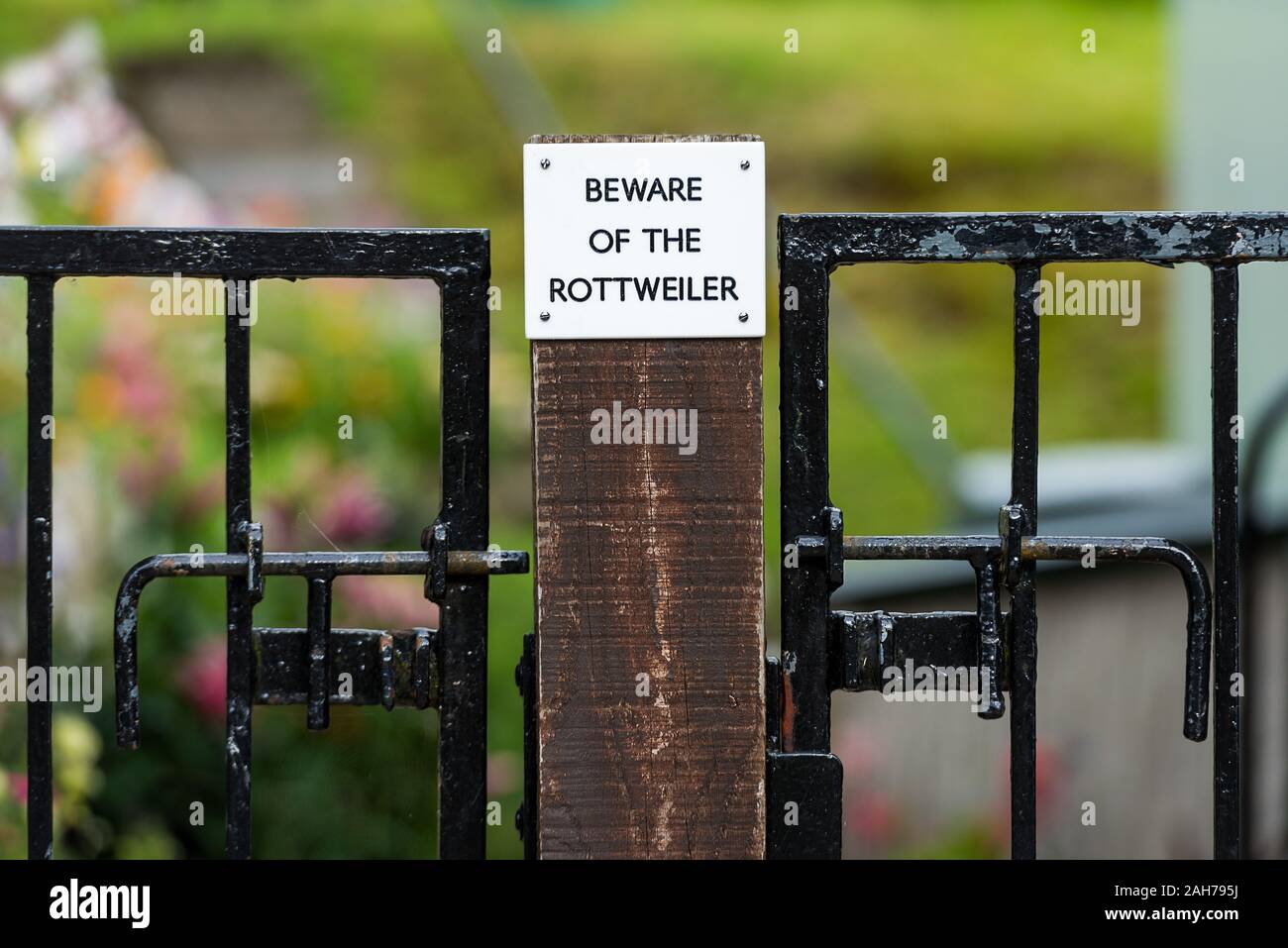 Symmetrical close up of a sign on a wooden fence warning against the dog Stock Photo