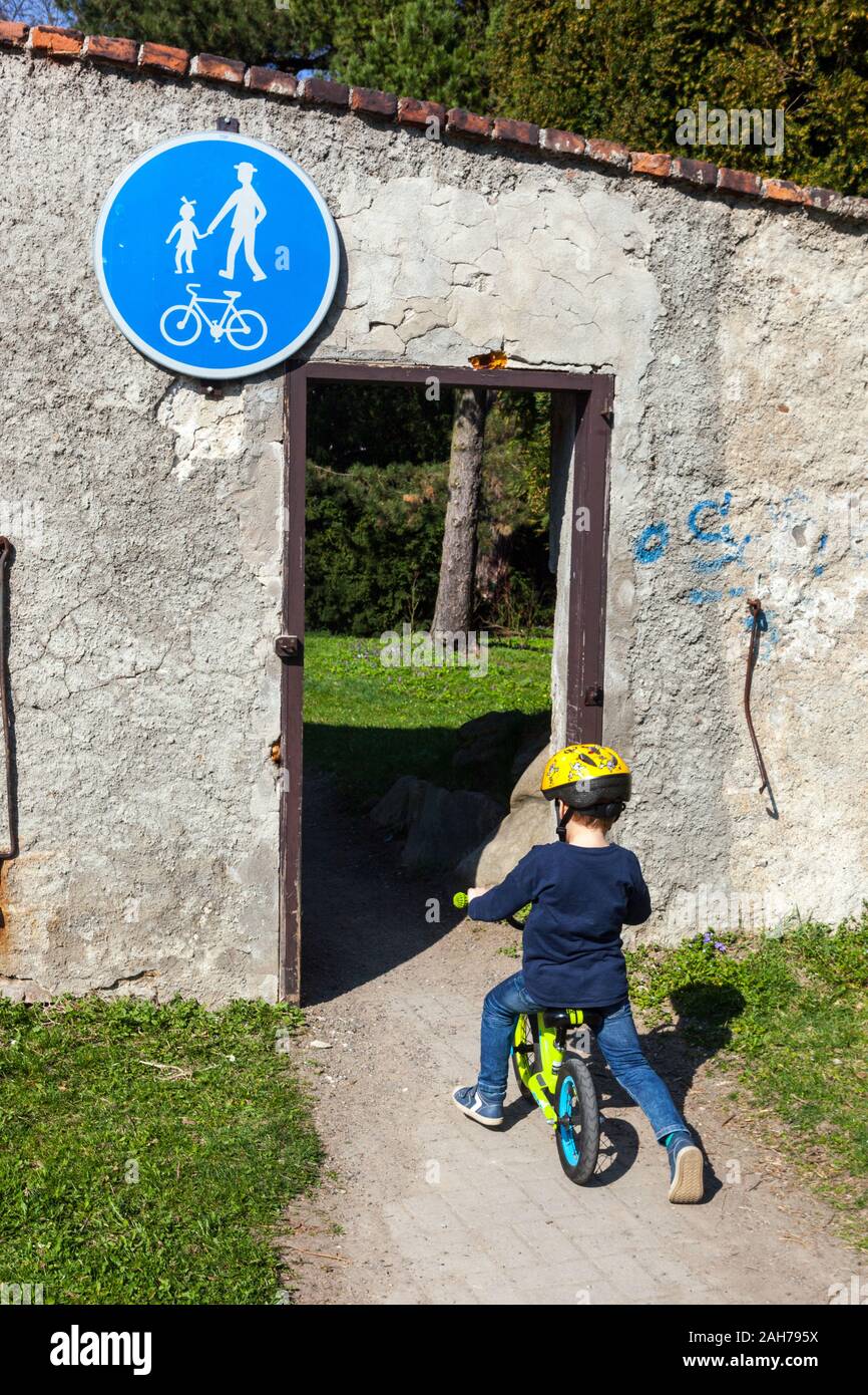 Toddler ride a bike to the park cycle path, bike helmet, child riding bike, bicycle toddler on bike, toddler alone rear Stock Photo