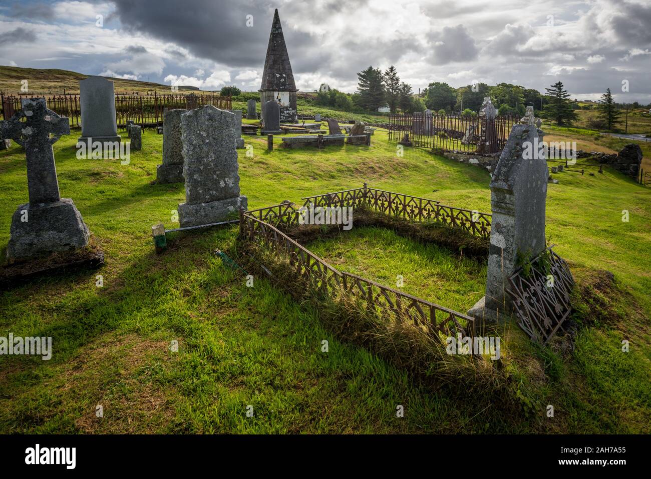 An ancient and abandoned scottish cemetery under a cloudy sky in the late afternoon light Stock Photo