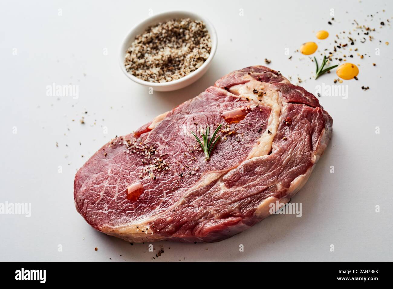 Portion of raw ribeye boneless beef steak marbled with fat seasoned ...