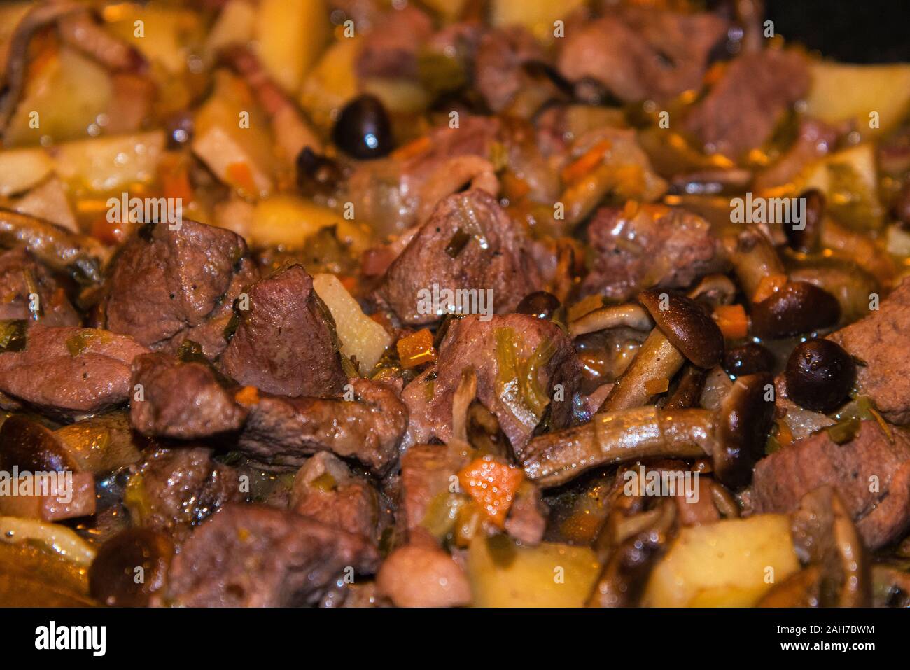 Wild boar stew with mushrooms and potatoes. Stock Photo